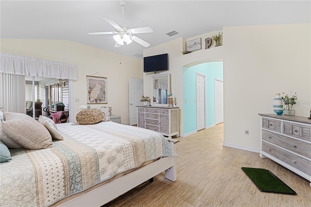 8980 SE 176th Limerick Ln, The Villages, FL 32162 - bedroom featuring vaulted ceiling, arched walkways, light wood-style floors, baseboards, and ceiling fan