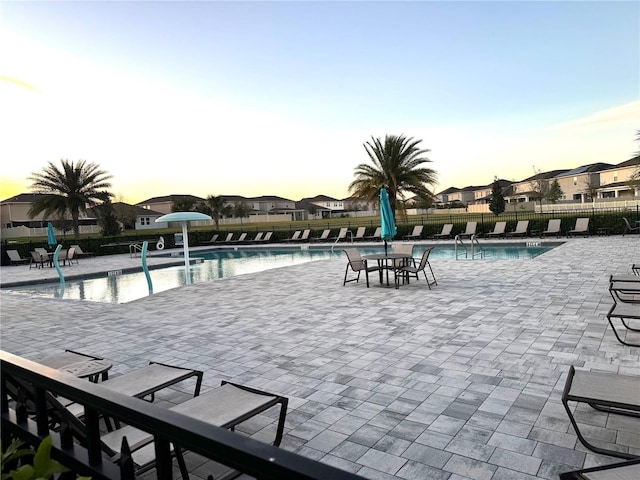 358 Switchgrass Loop, Minneola, FL 34715 - pool at dusk featuring a community pool and a patio