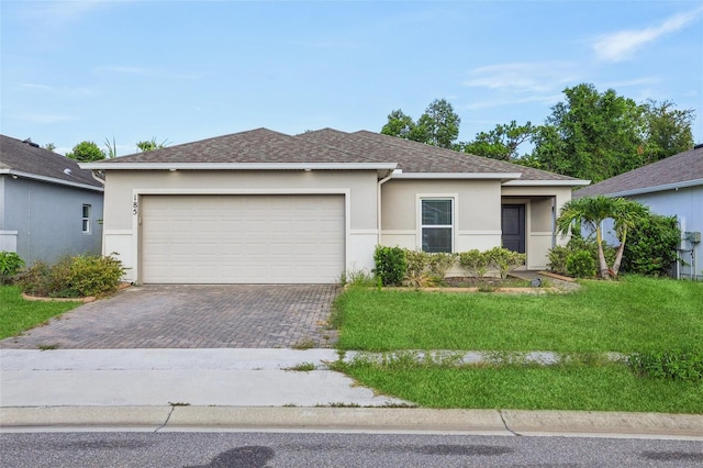 185 Hamlet Loop, Davenport, FL 33837 - ranch-style home featuring stucco siding, decorative driveway, an attached garage, and a front lawn