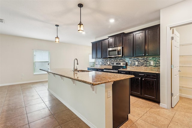185 Hamlet Loop, Davenport, FL 33837 - kitchen with stainless steel appliances, a kitchen bar, light tile patterned flooring, decorative backsplash, and light stone countertops
