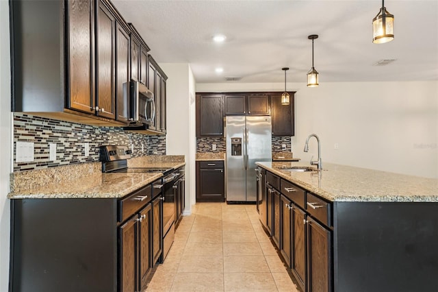 185 Hamlet Loop, Davenport, FL 33837 - kitchen featuring appliances with stainless steel finishes, decorative backsplash, light stone counters, an island with sink, and recessed lighting