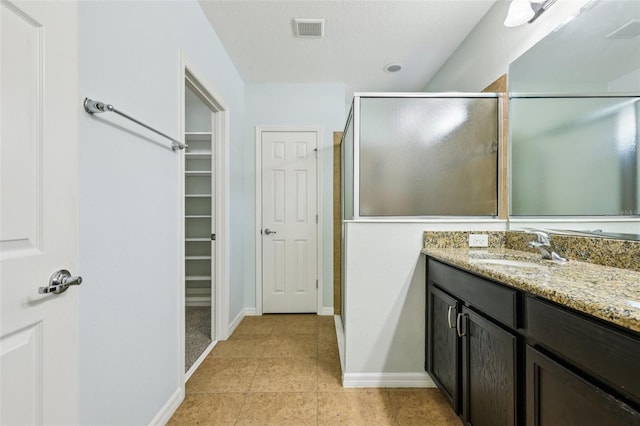 185 Hamlet Loop, Davenport, FL 33837 - bathroom with vanity, a shower stall, tile patterned floors, and a walk in closet