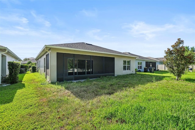 185 Hamlet Loop, Davenport, FL 33837 - back of property with stucco siding, a sunroom, and a lawn
