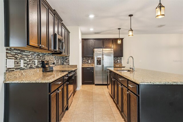 185 Hamlet Loop, Davenport, FL 33837 - kitchen with stainless steel appliances, backsplash, light stone countertops, a kitchen island with sink, and recessed lighting