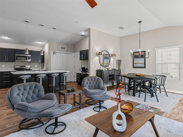 6301 Whittle Ct, The Villages, FL 32163 - living area with lofted ceiling, wood finished floors, baseboards, and a textured ceiling