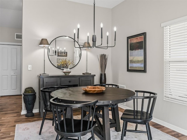 6301 Whittle Ct, The Villages, FL 32163 - dining space featuring a chandelier, wood finished floors, and baseboards
