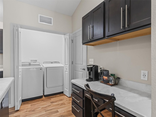 6301 Whittle Ct, The Villages, FL 32163 - laundry area with washer and clothes dryer, light wood-style flooring, cabinet space, and a desk