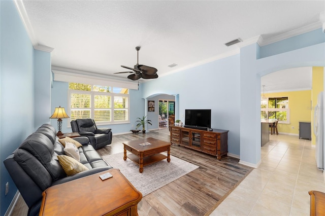 1910 Quiet Oak Ct, The Villages, FL 32162 - living room with arched walkways, a ceiling fan, crown molding, and baseboards