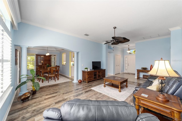 1910 Quiet Oak Ct, The Villages, FL 32162 - living area featuring ornate columns, arched walkways, a ceiling fan, crown molding, and wood finished floors
