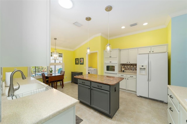 1910 Quiet Oak Ct, The Villages, FL 32162 - kitchen with white appliances, washer and dryer, a sink, white cabinets, and a center island