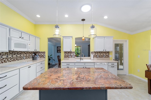 1910 Quiet Oak Ct, The Villages, FL 32162 - kitchen with white appliances, a sink, a kitchen island, vaulted ceiling, and arched walkways