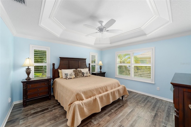 1910 Quiet Oak Ct, The Villages, FL 32162 - bedroom with multiple windows, a tray ceiling, wood finished floors, ornamental molding, and ceiling fan