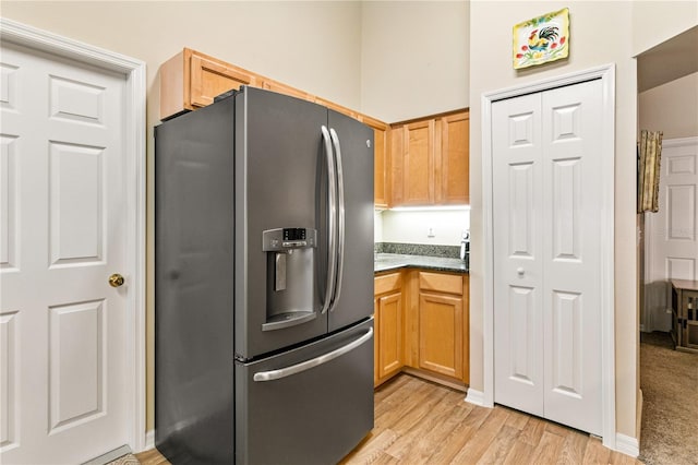 4083 Capland Ave, Clermont, FL 34711 - kitchen with stainless steel refrigerator with ice dispenser, light wood-style floors, and dark stone countertops