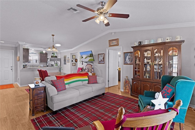 2785 Privada Dr, The Villages, FL 32162 - living area featuring ceiling fan, light wood finished floors, ornamental molding, a textured ceiling, and vaulted ceiling