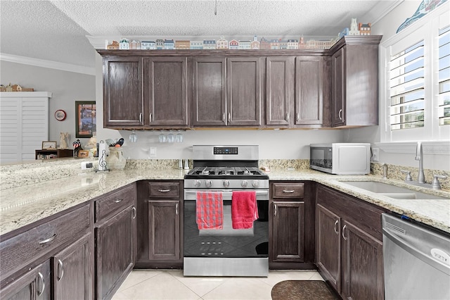 2785 Privada Dr, The Villages, FL 32162 - kitchen featuring stainless steel appliances, a sink, a textured ceiling, dark brown cabinets, and ornamental molding