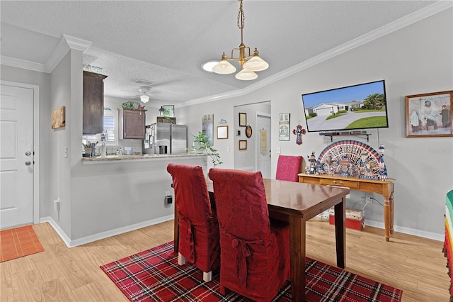 2785 Privada Dr, The Villages, FL 32162 - dining space featuring light wood-style floors, a chandelier, crown molding, a textured ceiling, and baseboards