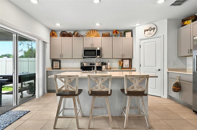 33960 Sky Blossom Cir, Leesburg, FL 34788 - kitchen with stainless steel appliances, a sink, gray cabinets, light countertops, and recessed lighting