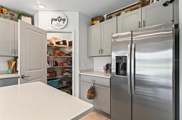 33960 Sky Blossom Cir, Leesburg, FL 34788 - kitchen with stainless steel fridge, light countertops, and gray cabinets