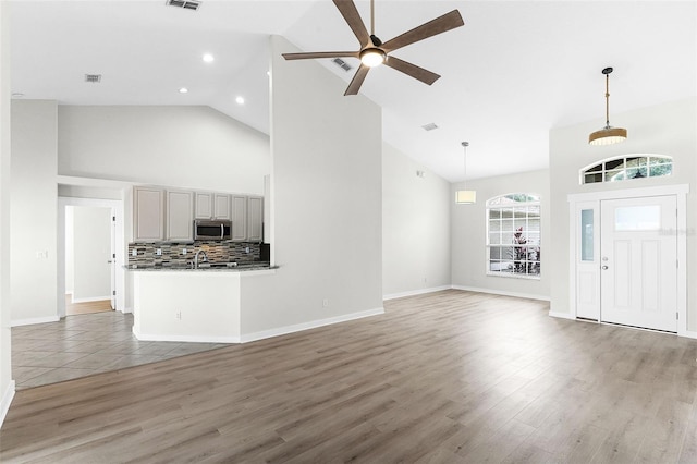 12838 Owasso Ln, Clermont, FL 34711 - unfurnished living room with high vaulted ceiling, ceiling fan, light wood-type flooring, recessed lighting, and baseboards