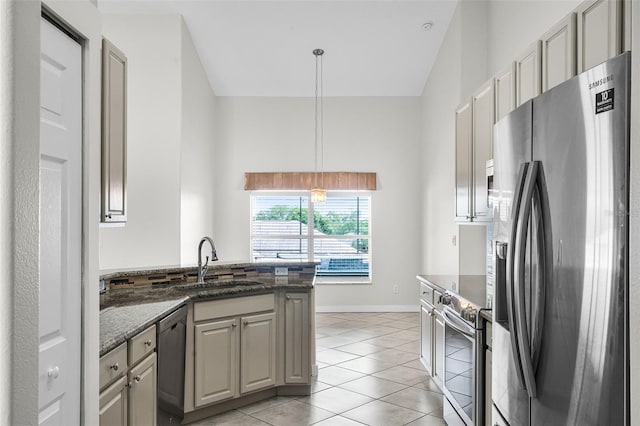 12838 Owasso Ln, Clermont, FL 34711 - kitchen featuring stainless steel appliances, a sink, a peninsula, light tile patterned flooring, and dark stone countertops