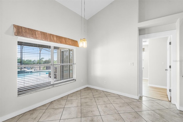 12838 Owasso Ln, Clermont, FL 34711 - empty room with high vaulted ceiling, light tile patterned floors, and baseboards