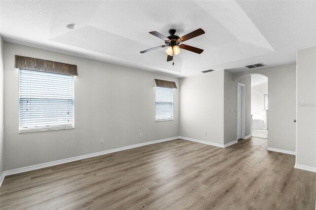 12838 Owasso Ln, Clermont, FL 34711 - empty room with arched walkways, a ceiling fan, wood finished floors, baseboards, and a smoke detector