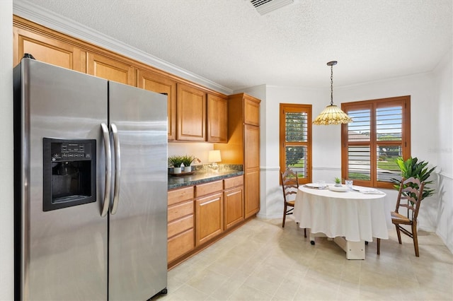 654 Fayette Ct, The Villages, FL 32162 - kitchen with stainless steel refrigerator with ice dispenser, dark countertops, brown cabinets, a textured ceiling, and ornamental molding