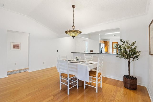 654 Fayette Ct, The Villages, FL 32162 - dining room featuring light wood-type flooring, crown molding, baseboards, and vaulted ceiling