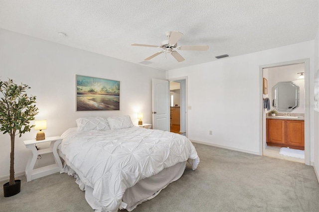654 Fayette Ct, The Villages, FL 32162 - bedroom featuring light carpet, a textured ceiling, a ceiling fan, ensuite bathroom, and baseboards