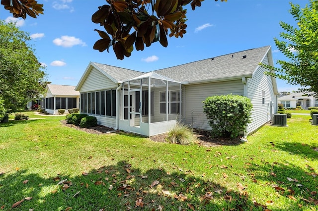 654 Fayette Ct, The Villages, FL 32162 - back of property featuring a sunroom, cooling unit, a shingled roof, and a yard