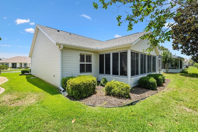 654 Fayette Ct, The Villages, FL 32162 - back of property with a sunroom, a shingled roof, and a lawn
