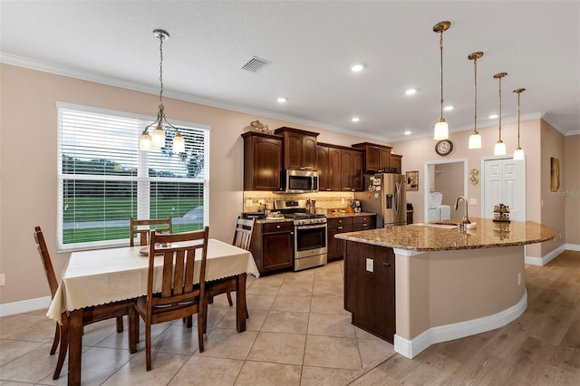 3809 Arlington Ridge Blvd, Leesburg, FL 34748 - kitchen with stainless steel appliances, a sink, dark brown cabinets, crown molding, and an island with sink
