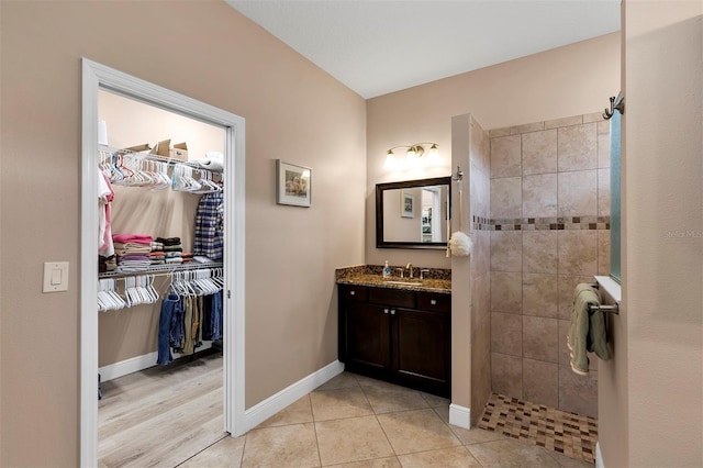 3809 Arlington Ridge Blvd, Leesburg, FL 34748 - bathroom featuring vanity, a tile shower, a walk in closet, and baseboards