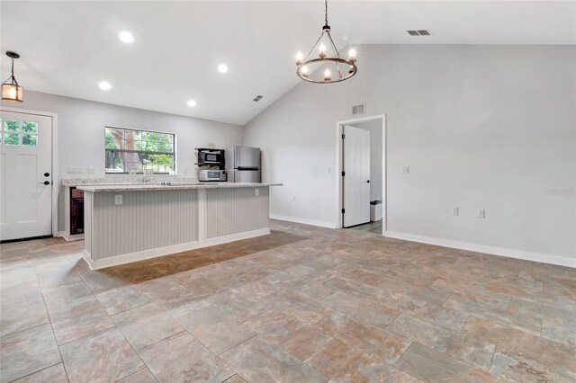 10330 Dwights Rd, Clermont, FL 34714 - kitchen with freestanding refrigerator, a chandelier, light countertops, a center island with sink, and decorative light fixtures