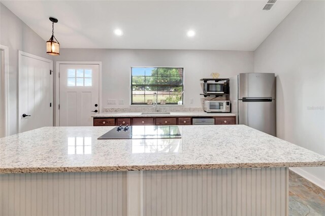 10330 Dwights Rd, Clermont, FL 34714 - kitchen with appliances with stainless steel finishes, a sink, light stone counters, pendant lighting, and recessed lighting