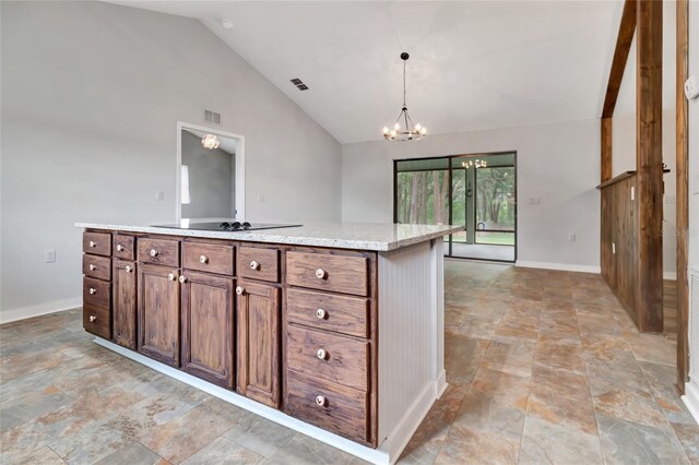 10330 Dwights Rd, Clermont, FL 34714 - kitchen featuring stone finish flooring, baseboards, a chandelier, hanging light fixtures, and high vaulted ceiling