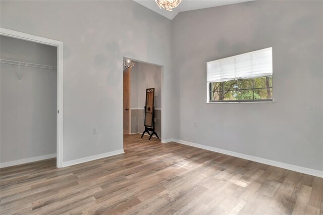 10330 Dwights Rd, Clermont, FL 34714 - unfurnished bedroom with a chandelier, wood finished floors, baseboards, a closet, and high vaulted ceiling