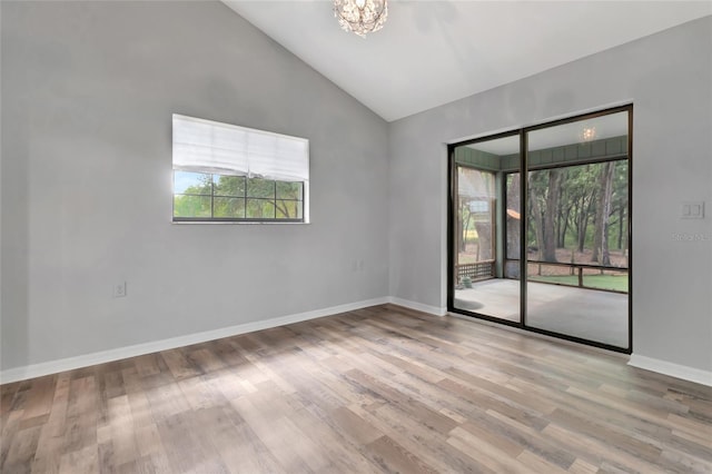 10330 Dwights Rd, Clermont, FL 34714 - empty room featuring healthy amount of natural light, a chandelier, lofted ceiling, wood finished floors, and baseboards