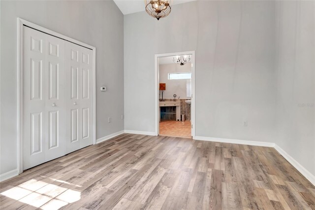 10330 Dwights Rd, Clermont, FL 34714 - unfurnished bedroom with a chandelier, light wood finished floors, a closet, baseboards, and a towering ceiling