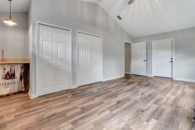 10330 Dwights Rd, Clermont, FL 34714 - unfurnished bedroom featuring lofted ceiling, two closets, wood finished floors, and baseboards