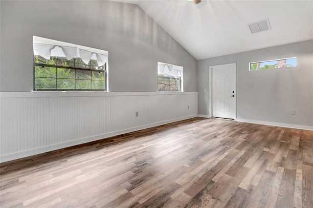 10330 Dwights Rd, Clermont, FL 34714 - spare room featuring plenty of natural light, wood finished floors, high vaulted ceiling, and a wainscoted wall