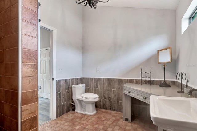 10330 Dwights Rd, Clermont, FL 34714 - bathroom with tile walls, a wainscoted wall, toilet, and a sink