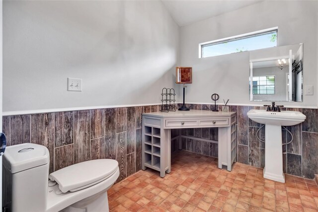 10330 Dwights Rd, Clermont, FL 34714 - half bathroom with toilet, a wainscoted wall, tile walls, and a sink