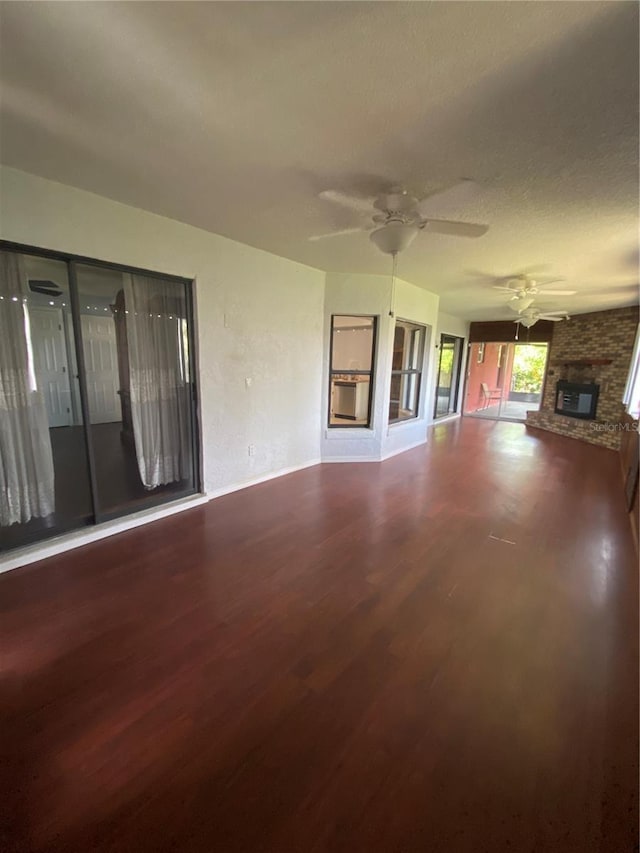 901 Baylor Dr, Deltona, FL 32725 - unfurnished living room featuring wood finished floors, a large fireplace, ceiling fan, and baseboards