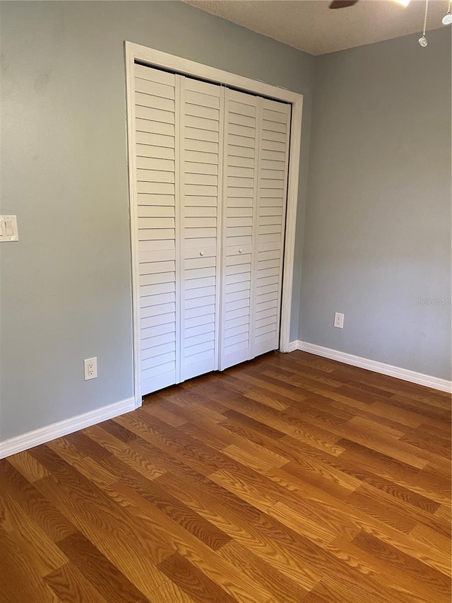 901 Baylor Dr, Deltona, FL 32725 - unfurnished bedroom featuring dark wood-type flooring, baseboards, and a closet