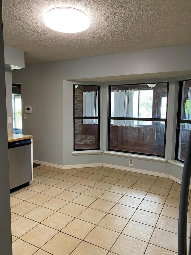 901 Baylor Dr, Deltona, FL 32725 - unfurnished room featuring a textured ceiling, light tile patterned floors, healthy amount of natural light, and baseboards