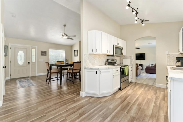 40140 Palm St, Lady Lake, FL 32159 - kitchen featuring stainless steel appliances, a ceiling fan, arched walkways, decorative backsplash, and light countertops