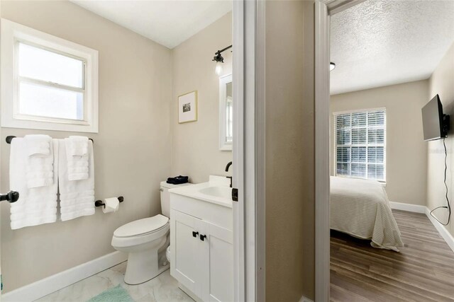40140 Palm St, Lady Lake, FL 32159 - bathroom featuring vanity, baseboards, ensuite bath, toilet, and wood finished floors