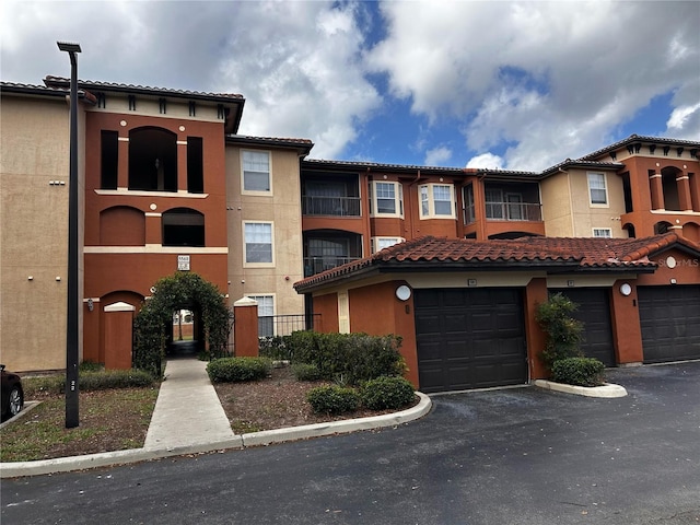 5560 Metrowest Blvd Unit 3-204, Orlando, FL 32811 - view of front of house featuring stucco siding, a tiled roof, and driveway