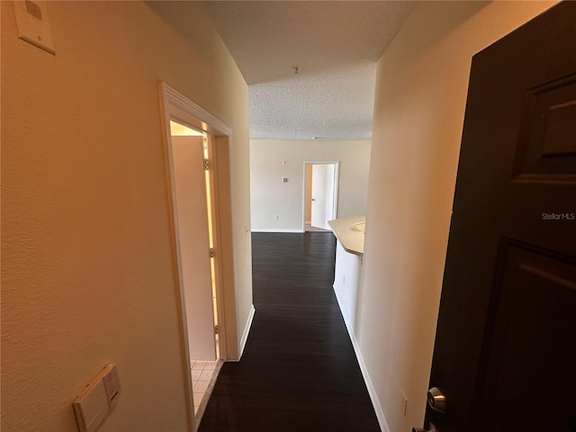 5560 Metrowest Blvd Unit 3-204, Orlando, FL 32811 - hall featuring dark wood-type flooring, a textured ceiling, and baseboards